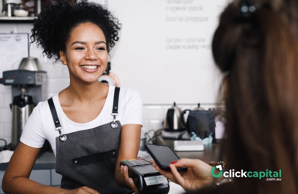 happy staff receiving mobile payment from a customer in the counter