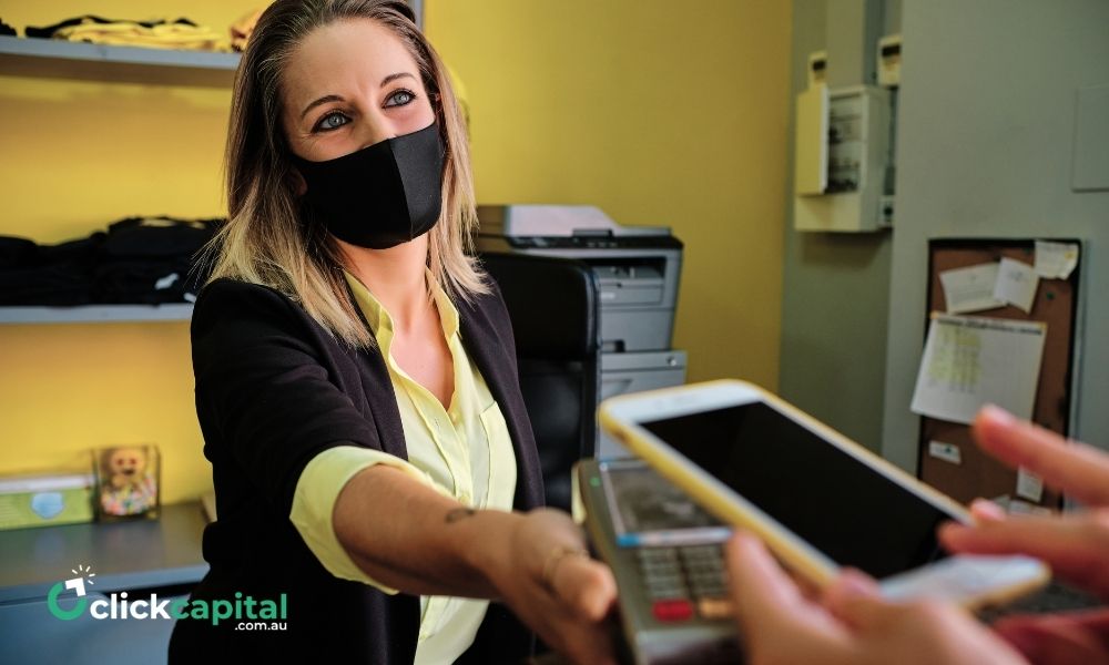 business owner with a mask doing Cashless transaction Using Smartphone