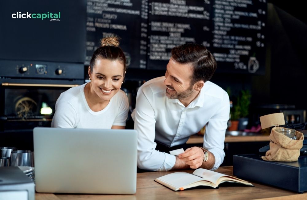 two happy business owners doing cash management in front of laptop in the cafe