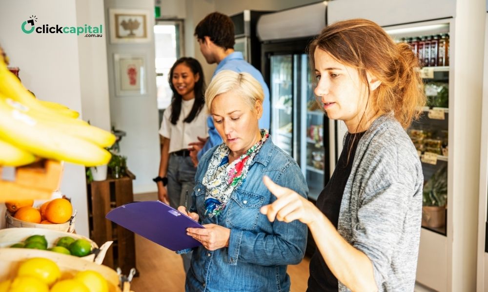 business owners of a small urban grocery store checking inventory